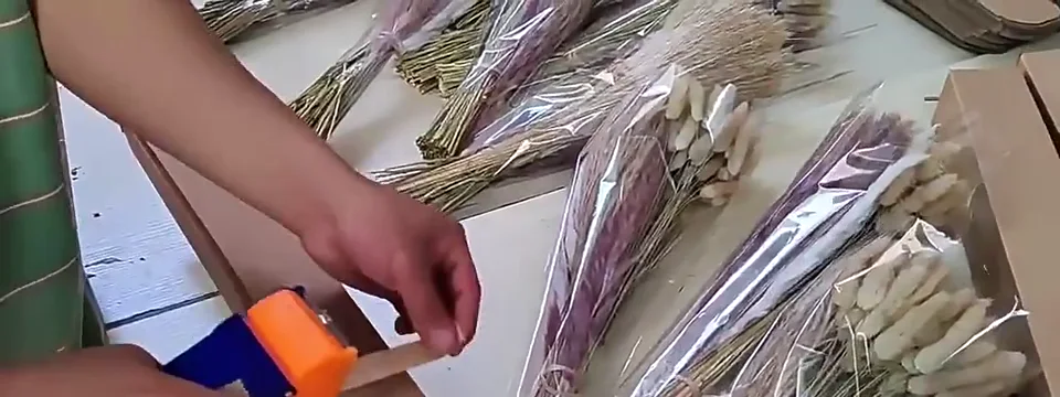 Dried flower bouquets being measured and prepared for fitted boxes
